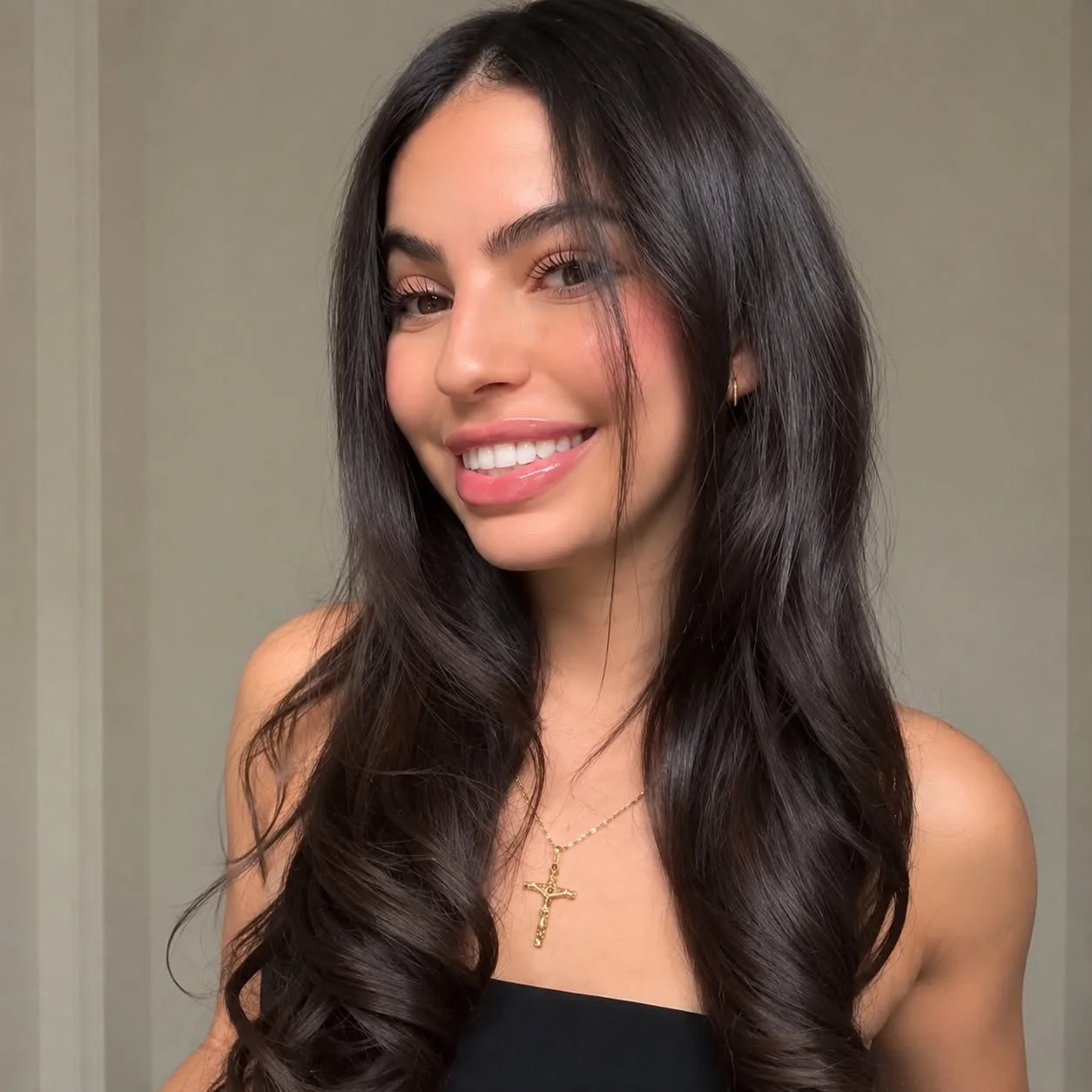 Smiling, with long glossy dark brunette waves